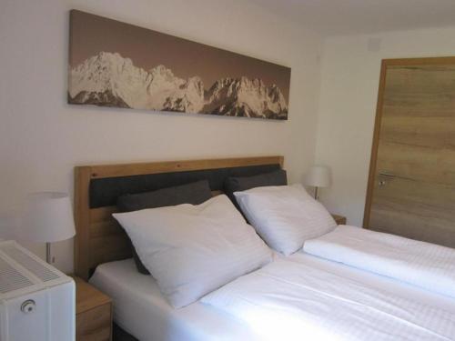 ein Schlafzimmer mit einem Bett mit weißen Kissen in der Unterkunft Haus Kohlbründl in Saalbach-Hinterglemm