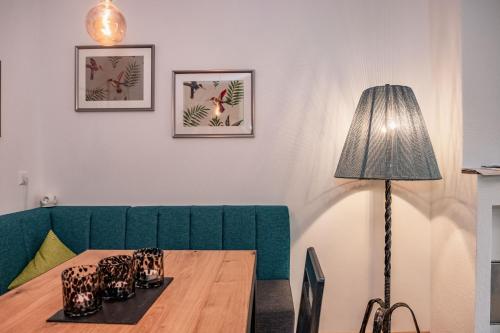 a room with a table and a green couch and a lamp at Berg Apartment-Berg im Drautal in Berg im Drautal
