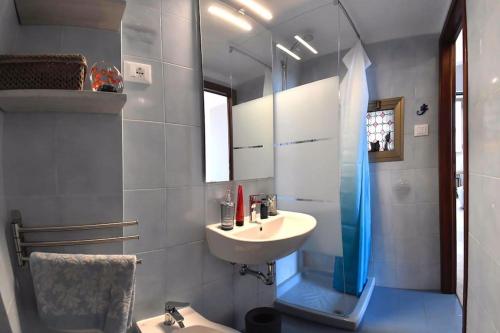 y baño con lavabo y ducha con espejo. en Il Garibaldino en Livorno