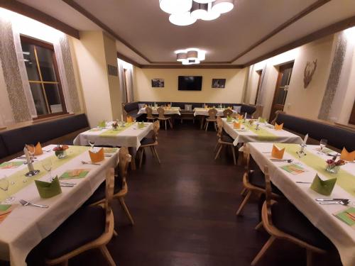 a row of tables in a restaurant with white tables at Hotel Landgasthof Frankenstern in Gößweinstein
