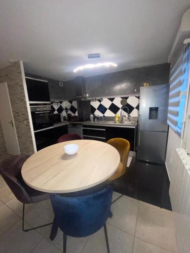 een keuken met een houten tafel en blauwe stoelen bij Appartement duplex T3 - Paris Jeux Olympiques - Roissy CDG - Parc des expositions - Disney - Astérix in Villepinte