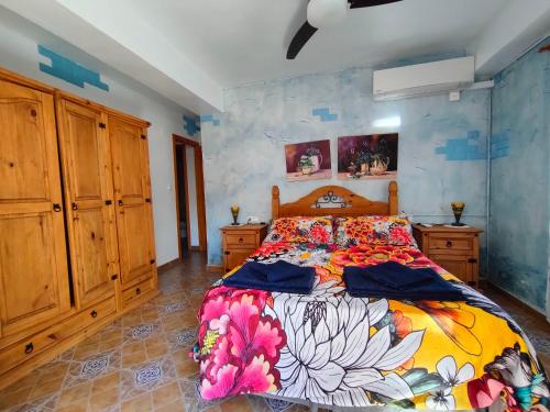 グアルダマル・デル・セグラにあるApartamento Maiteのベッドルーム(大型ベッド1台、木製キャビネット付)
