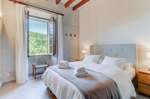 a bedroom with a large bed and a window at U Vila in Pollença