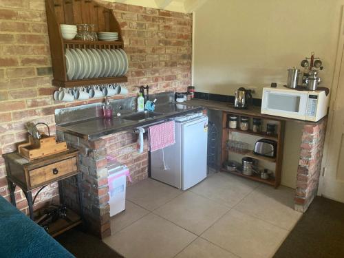 een keuken met een witte koelkast en een magnetron bij Arden Country House BnB in Dunedin
