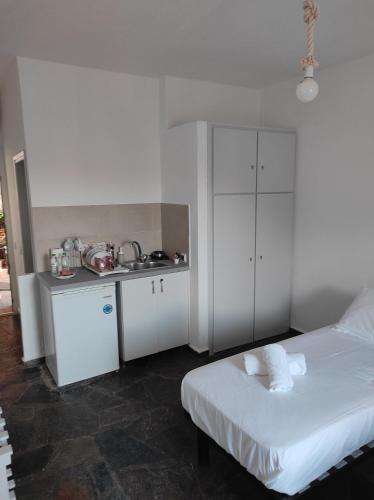 a white bedroom with a bed and a kitchen at Kea Island in Korissia