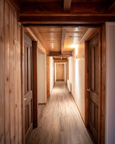 a hallway in a house with wooden floors and doors at HOTEL VOLKANICO in Curacautín