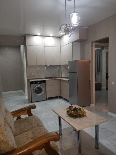 eine Küche mit einem Tisch und einem Kühlschrank in der Unterkunft Квартира в аренду in Tbilisi City