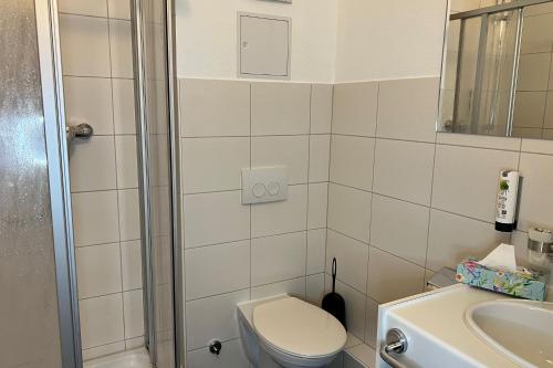 a bathroom with a toilet and a sink and a shower at SKYBASIC Merseburg in Merseburg