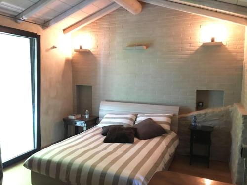 a bedroom with a bed with two pillows on it at Brick house in Sommacampagna