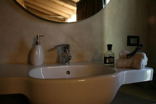 Brick house في سوماكامبانا: بالوعة بيضاء في الحمام مع مرآة