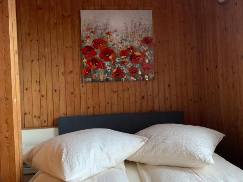 a bedroom with two pillows and a painting on the wall at Romantische Ferienwohnung Metzner in Remptendorf