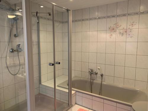y baño con ducha y bañera. en Romantische Ferienwohnung Metzner, en Remptendorf