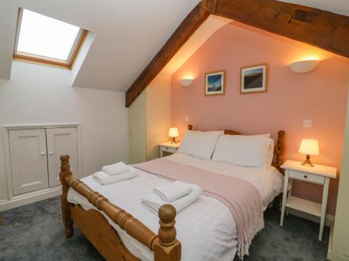 a bedroom with a large bed with two tables and two lamps at Clover Cottage in Kirkby Stephen
