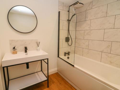 a bathroom with a sink and a shower and a mirror at Clover Cottage in Kirkby Stephen