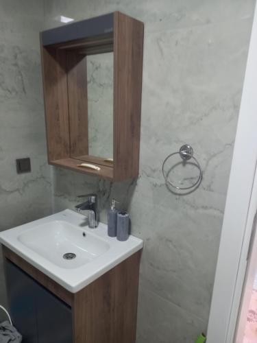 een badkamer met een wastafel en een spiegel bij Yaz kış güzel manzaralı ev in Bodrum City