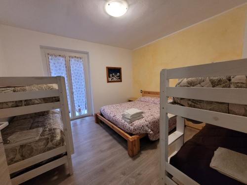 a bedroom with two bunk beds and a window at Green House Mountain Lake Iseo Hospitality in Bossico