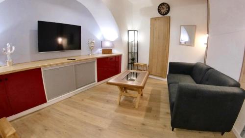 a living room with a couch and a tv at studio entre terre et ciel - escapade millavoise in Millau