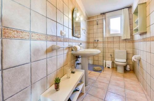 een badkamer met een wastafel en een toilet bij Casa de vacaciones in Teulada