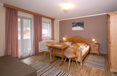 a bedroom with a bed and a desk and a table at Landhaus Tyrol in Mayrhofen