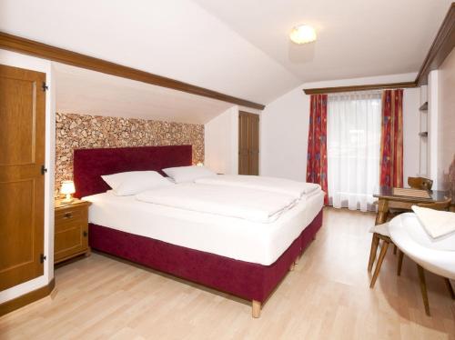 ein Schlafzimmer mit einem großen weißen Bett und einem Waschbecken in der Unterkunft Landhaus Tyrol in Mayrhofen