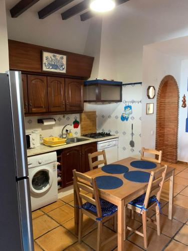 a kitchen with a table and chairs and a refrigerator at A Casa da avó Custodinha in Bias do Norte