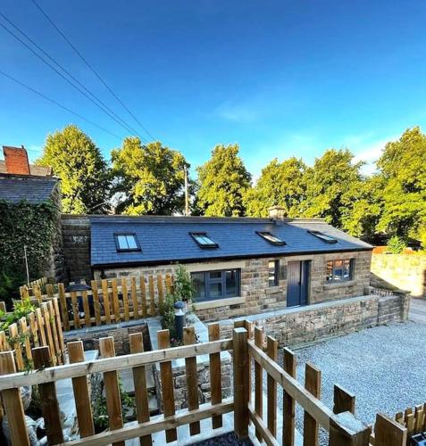 a brick house with a wooden fence in front of it at The Watchmakers Matlock in Matlock