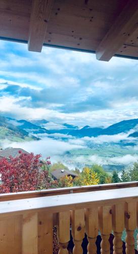 a balcony with a view of the mountains and clouds at AmStein in Kaltenbach