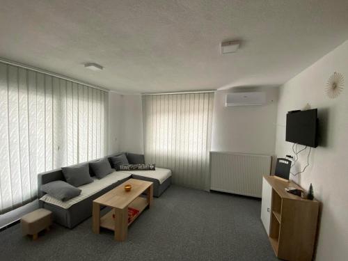 a living room with a couch and a table at Imperial exclusive apartments in Velika Kladuša