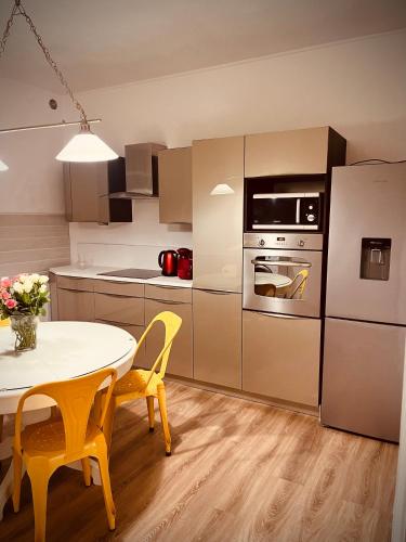 une cuisine avec une table, des chaises et un réfrigérateur dans l'établissement Petit prince chambre à louer, à Saint-Dié-des-Vosges