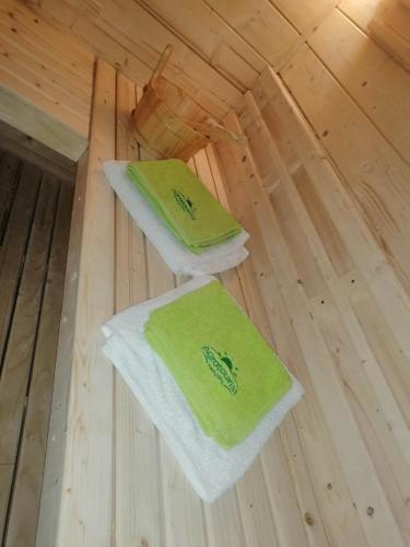 two green towels sitting on top of a wooden floor at Agrotourist Maryska Małe Leźno in Małe Leżno