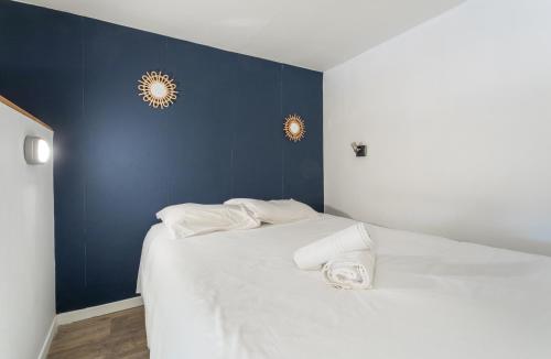 a bedroom with a white bed with a blue wall at Au 21 rue Victor Hugo in Trouville-sur-Mer