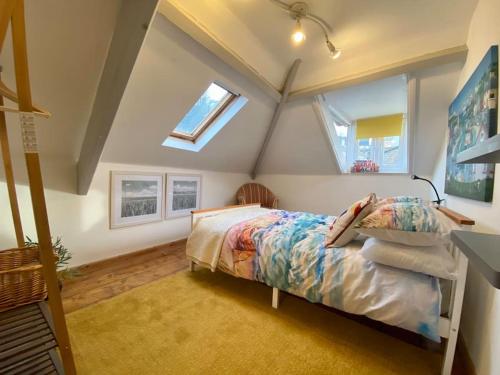 a attic bedroom with a bed and a window at Four-tunes just 2 mins walk from Torquay harbour in Torquay