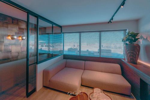 a living room with a couch and a window at Luxueus genieten aan zee: private jacuzzi en sauna in Knokke-Heist