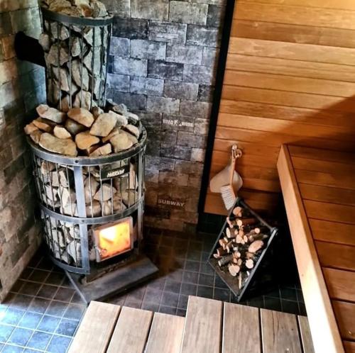 a fireplace in a room with a pile of rocks at Ainutlaatuinen huoneisto Vanhassa kyläkoulussa 