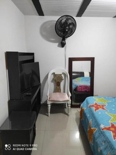 1 dormitorio con 1 cama, TV y silla en Lindo Apartamento Sector Estrato 5, en Ibagué