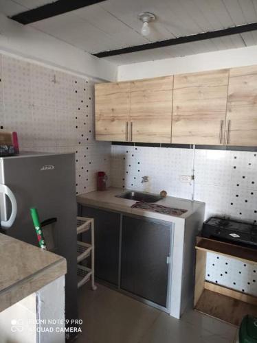 cocina con armarios de madera y nevera gris en Lindo Apartamento Sector Estrato 5, en Ibagué