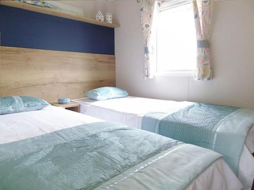 a bedroom with two beds and a window at Leylandii 2 Bed Holiday Home in picturesque town. in Knaresborough