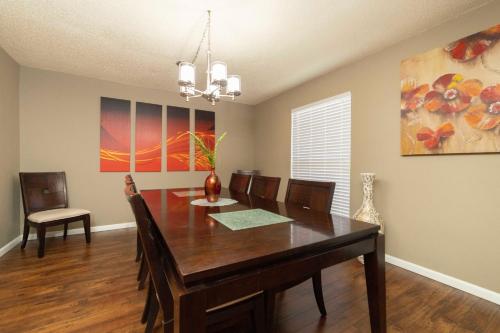 a dining room with a wooden table and chairs at Stylish Townhome with Shared Pool Access in Gated Complex in San Antonio