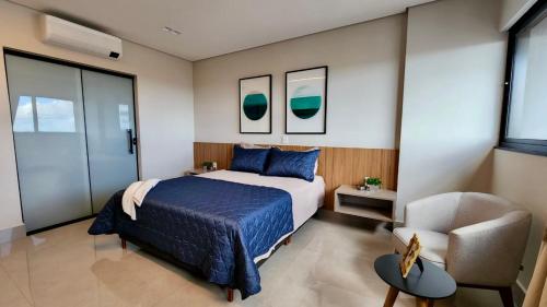 a bedroom with a bed and a chair at Flat de Luxo c/ Quarto Privativo 21º Andar Vertigo in Campo Grande