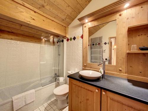 a bathroom with a sink and a toilet and a mirror at Bells Lodge in Chamonix-Mont-Blanc