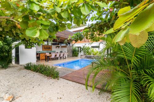 een achtertuin met een zwembad en een tafel en stoelen bij Little Hawaii Avellanas in Playa Avellana