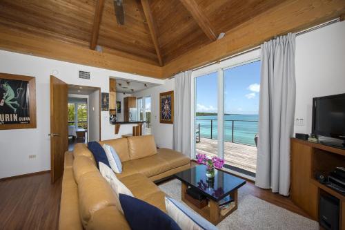 a living room with a couch and a view of the ocean at Touch of Class home in Savannah Sound