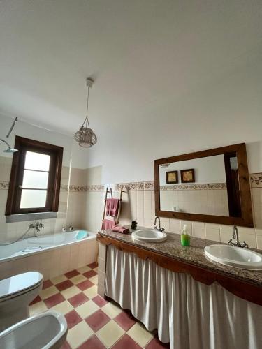 a bathroom with two sinks and a tub and a mirror at Aproveite o sabor do Alentejo in Vila Verde de Ficalho