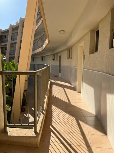 a corridor of a building with a balcony at Neot Golf, Ziv's Place in Caesarea