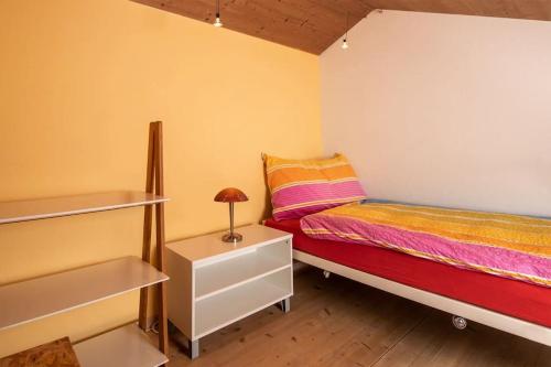 a small bedroom with a bed and a night stand at Hadassa Apartment Maranatha / Selah in Steffisburg