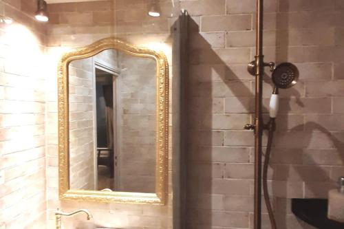 uma casa de banho com um espelho numa parede de tijolos em Midnight in Paris Montmartre em Paris