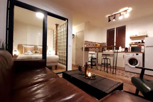 un salon avec un canapé en cuir et une cuisine dans l'établissement Midnight in Paris Montmartre, à Paris