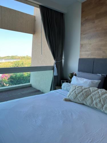 a bedroom with a large bed with a large window at Neot Golf, Ziv's Place in Caesarea