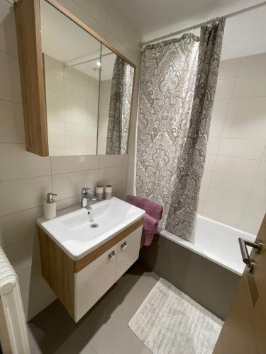 a bathroom with a sink and a tub and a mirror at Mi's Apartment in Matrei am Brenner