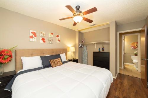 a bedroom with a white bed and a ceiling fan at Stylish Townhome with Shared Pool Access in Gated Complex in San Antonio